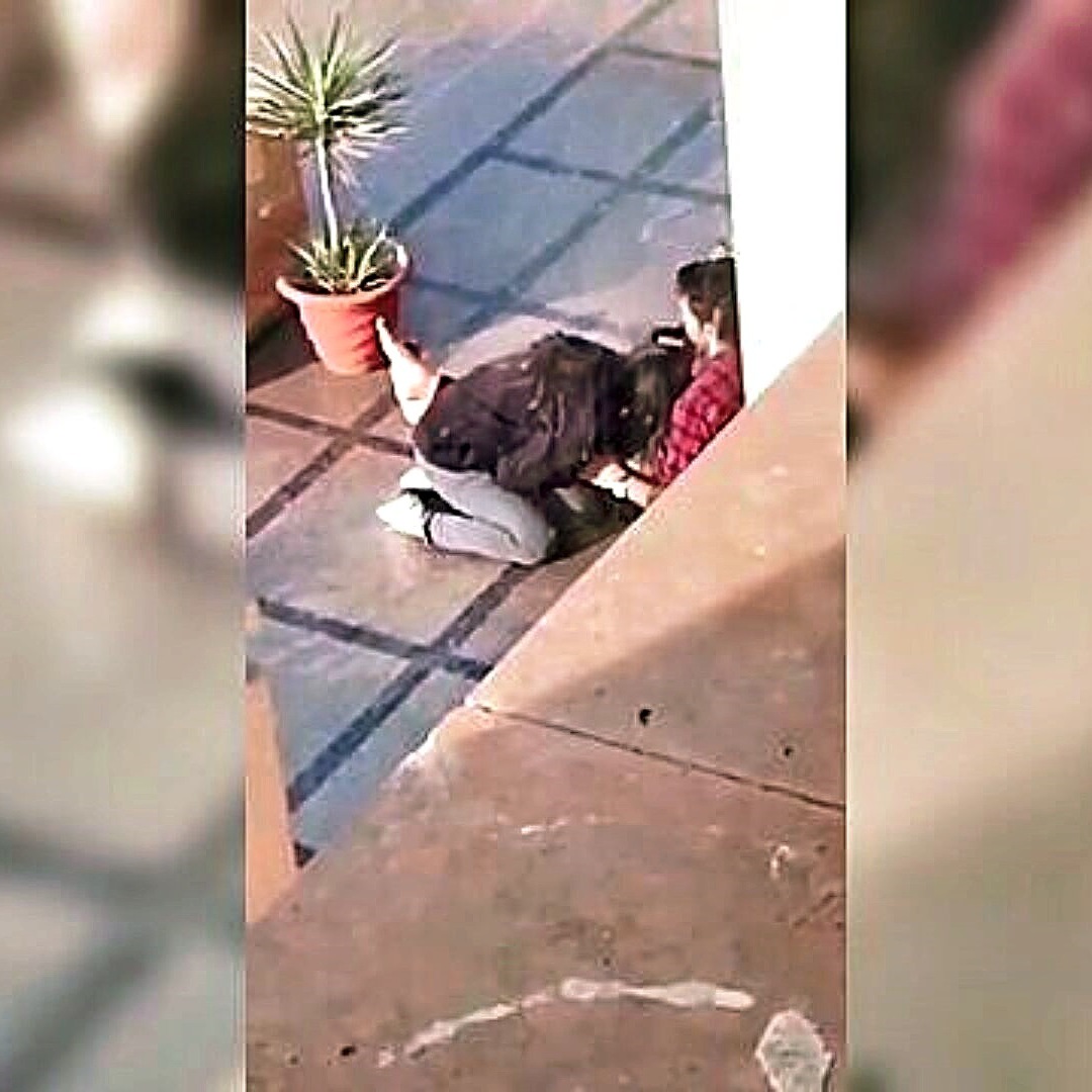 A couple in an intimate embrace, partially hidden in an outdoor setting